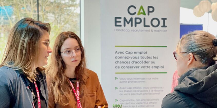 Conseillères Cap Emploi discutant avec un visiteur du Salon de l'Emploi et de la Formation Professionnelle au stade Gaston-Gérard du DFCO à Dijon